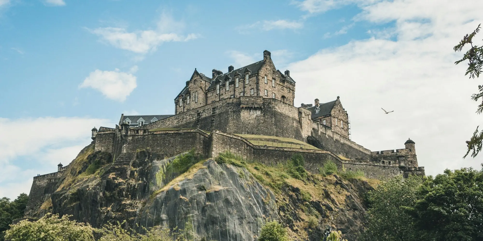 Edinburgh Castle auf dem Felsen über der Stadt bei leicht bewölktem Himmel