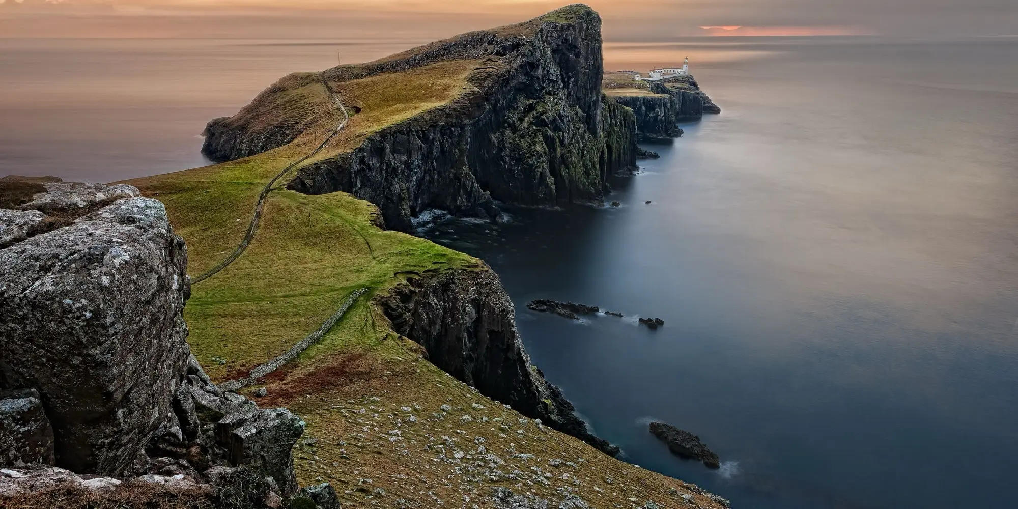 Grüne Landzunge mit Steilklippen über dem Meer an der Westküste der Isle of Skye